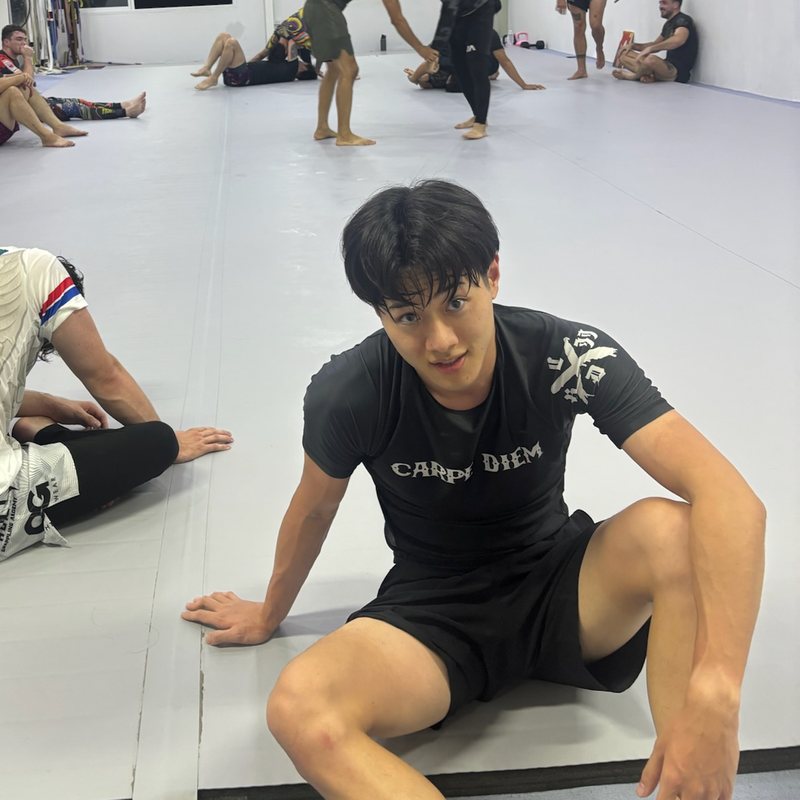 Jin sitting on the mats after a no-gi jiu-jitsu class